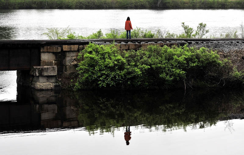 ALONE: Paula Berry, daughter of missing driver Cora Marley, stands alone while looking for signs of her mother where Martin Stream and the Kennebec River meet in Hinckley on Wednesday.