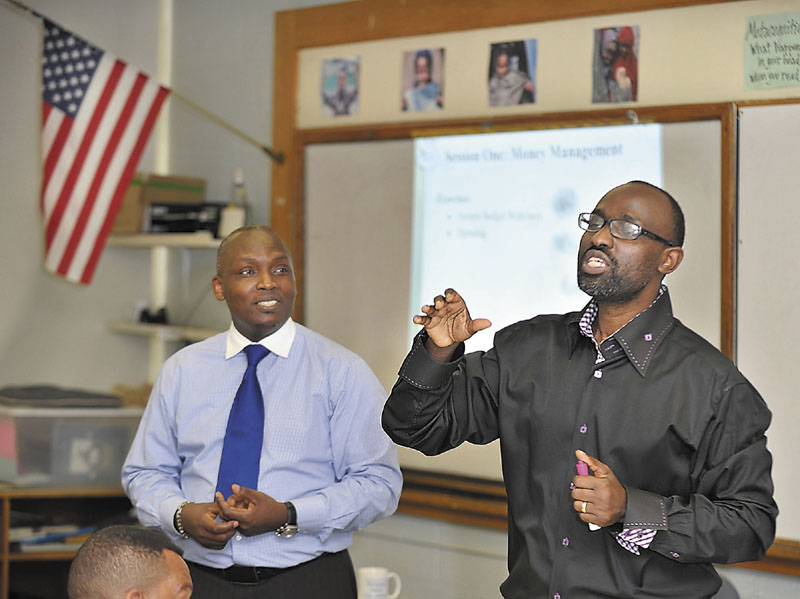 Claude Rwaganje, right, teaches a class on responsible finance management at the Portland Adult Education Center. He is helped by assistant teacher, Clement Yombe, who also translated for the French speaking students who attend with other immigrants, low-income and "unbanked" residents.