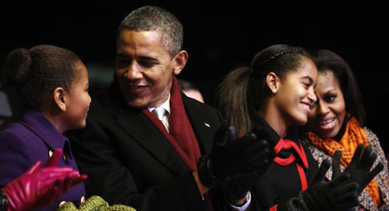 In this December 2011 photo, President Barack Obama spends time with his wife, Michelle, and daughters Sasha and Malia. Obama is attempting to woo Hispanic voters in part with Spanish-language commercials focusing on his image as a strong family man.