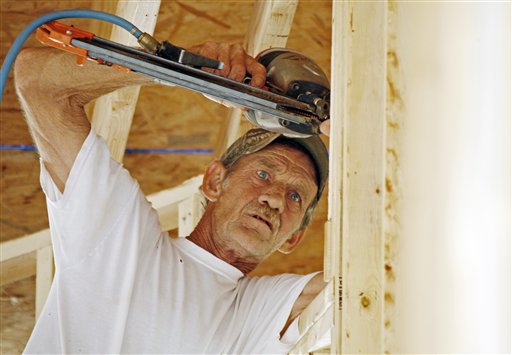 John Knight uses an air hammer as he frames a new house on a lot in Pearl, Miss., recently. Confidence among U.S. builders ticked up in June to a five-year high, an indication that the housing market is slowly improving.