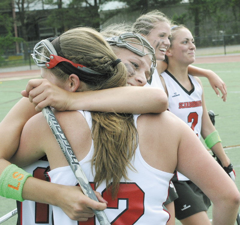 WE DID IT: Scarborough’s Laura Przybylowicz and Mary Scott hug after defeating Brunswick for the Class A girls lacrosse state championship Saturday at Fitzpatrick Stadium in Portland.