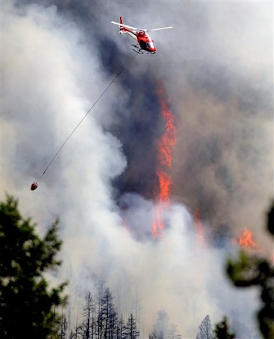 A firefighting helicopter flies above the Flagstaff fire on Tuesday, June 26, 2012 west of Boulder, Colo. Colorado has endured nearly a week of 100-plus-degree days and low humidity, sapping moisture from timber and grass, creating a devastating formula for volatile wildfires across the state and punishing conditions for firefighters. (AP Photo/The Boulder Daily Camera, Jeremy Papasso)