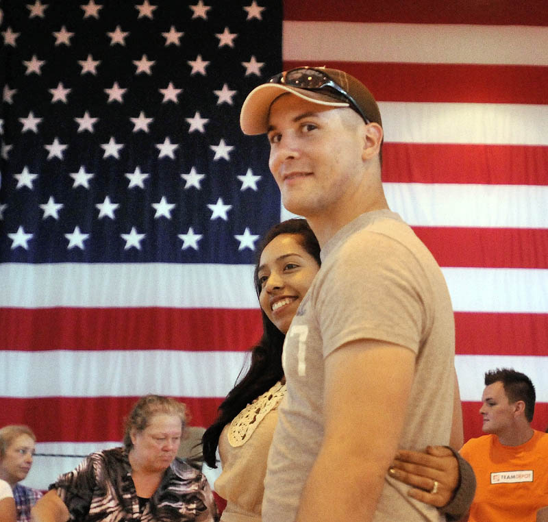 DEPLOYING: Spc. Jason Pepin, center, and his wife Estela wait in line for food at Sunday’s celebration at the Waterville Armory.