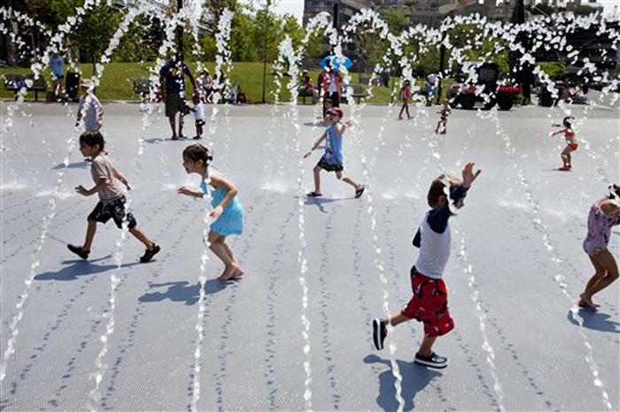 Children run through the fountains at Georgetown Waterfront Park in Washington today.