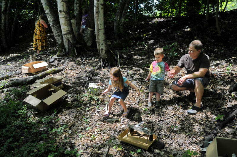 Katelin Sieberg, 5, sets out a fairy house with her brother, Tyler, 3, and father, Rick, Thursday in Gardiner.