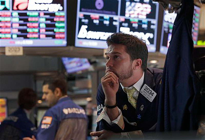 Specialist Joseph Dreyer, right, watches the decision of the Federal Reserve as he works at his post on the floor of the New York Stock Exchange Wednesday, June 20, 2012. The Federal Reserve is extending a program designed to drive down long-term interest rates to spur borrowing and spending. (AP Photo/Richard Drew)