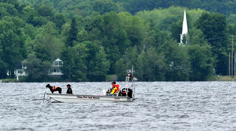 Searchers with the Maine Warden's Service search an area of China Lake for missing swimmer, Tye Feihel, 43, on Tuesday. Feihel was reported missing when he didn't return from his usual afternoon swim.
