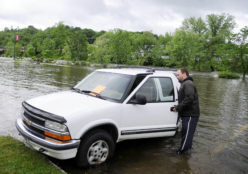 Ryan Crouse removes his truck Monday afternoon from the rising Cobbossee Stream in the arcade lot in Gardiner. City officials ordered all the vehicles in the arcade lot be removed ahead of flooding, when Crouse was at work.