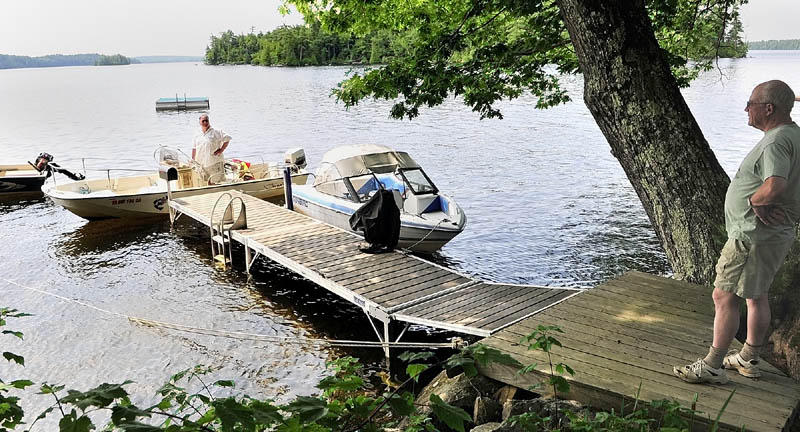 Norm Shaw, left, visits with customer Ed Slattery while making his round on Thursday. He has been delivering the mail from his boat on Great Pond in Belgrade and Rome for nine years.