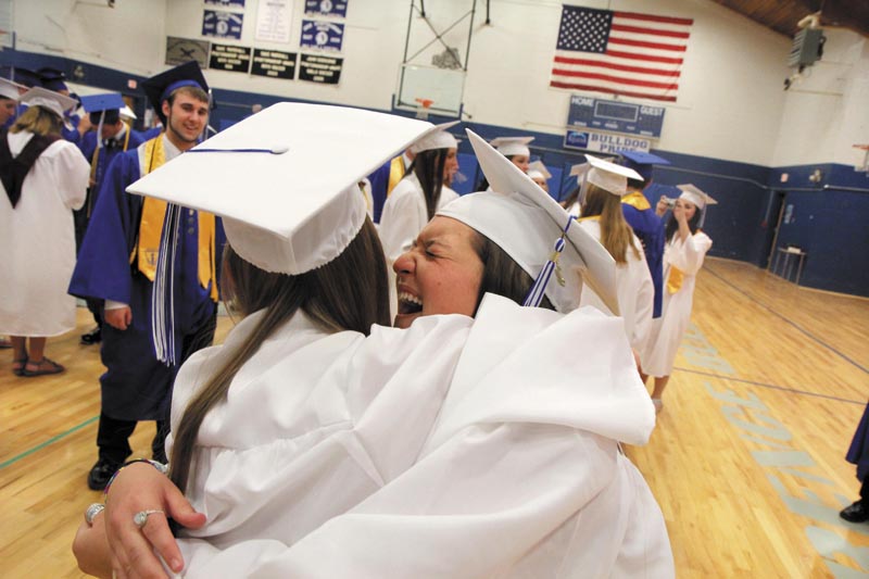 A REASON TO SMILE: Emily Lambert gives Regan LaPorte a hug prior to the start of graduation exercises at Lawrence High School in Fairfield on Friday night.