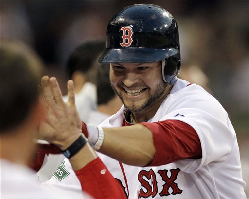 Boston Red Sox's Cody Ross is congratulated at the dugout after hitting a solo homer in the fourth inning against the Miami Marlins during an interleague baseball game at Fenway Park in Boston on Tuesday, June 19, 2012. (AP Photo/Elise Amendola)