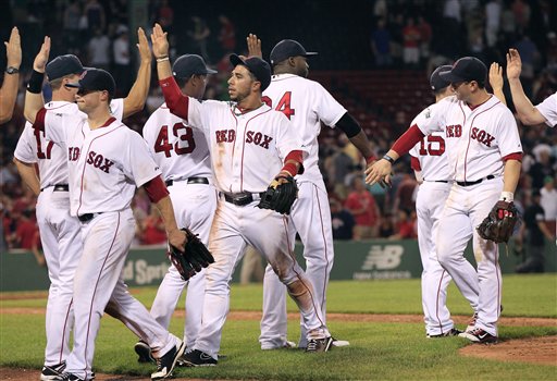 Boston Red Sox players, including shortstop Mike Aviles, center, celebrate their 15-5 victory over the Miami Marlins in an interleague baseball game at Fenway Park in Boston on Wednesday, June 20, 2012. (AP Photo/Elise Amendola)