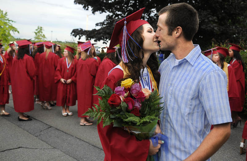 MOVING ON: Messalonskee High School senior Molly Ayotte, of Sidney, kisses her boyfriend, Caleb Bragg, of Sidney, before graduation Thursday in Augusta.