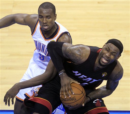 Miami Heat small forward LeBron James is defended by Oklahoma City Thunder power forward Serge Ibaka (9) from Republic of Congo during the first half at Game 2 of the NBA finals basketball series, Thursday, June 14, 2012, in Oklahoma City.