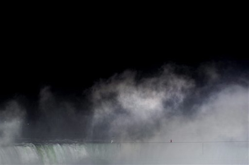 Nik Wallenda walks a tightrope over Niagara Falls as seen from Niagara Falls, Ontario, on Friday, June 15, 2012. Wallenda has finished his attempt to become the first person to walk on a tightrope 1,800 feet across the mist-fogged brink of roaring Niagara Falls. The seventh-generation member of the famed Flying Wallendas had long dreamed of pulling off the stunt, never before attempted. (AP Photo/The Canadian Press, Nathan Denette) general;art;artistic;arts;Canada;Canadian;Ent;entertain;entertainer;entertainers;entertaining;entertainment;performance;performing;expression;image;photograph;photographed;picture;portraits;pose;poses;posing;profile;portrait;Falls;Tight;Tight rope;Walk;Danger;Water;Waterfalls;United States;USA;Wire;Conditions;Wet;River;Hight;Fall;Slip;Mist;Lights;Distance;Feet;Meters;Audience;High;Balance;Pole;Beam;Victory;Accomplish;balance beam;acrobat;acrobatics;apparaus;athlete;athletes;athletic;athletics;competative;compete;competing;competition;competitions;event;exercise;gym;parallel;rhythm;routine;skill;skills;sport;sporting;sports;gymnastics