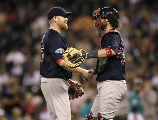 Boston Red Sox starting pitcher Aaron Cook, left, greets catcher Jarrod Saltalamacchia, right, after Cook threw a two-hit shutout against the Seattle Mariners in a baseball game, Friday, June 29, 2012, in Seattle. The Red Sox beat the Mariners 5-0. (AP Photo/Ted S. Warren)