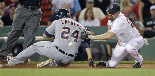 Boston Red Sox third baseman Kevin Youkilis applies a tag without the ball as Detroit Tigers' Miguel Cabrera advances to third on a throwing error, after stealing second base during the ninth inning of a baseball game at Fenway Park in Boston, Thursday, May 31, 2012. (AP Photo/Charles Krupa)
