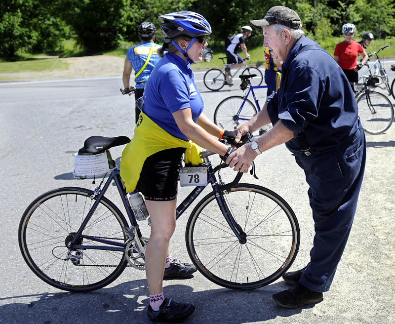 DELICATE BALANCE: Leo Smith helps Trek Across Maine biker Kris Ebbeson, of Rochester, NH, keep her balance Sunday after she climbed to the summit of a hill on Route 3 in Palermo, near Smith's home. Several hundred riders crossed Maine this weekend to raise funds for the American Lung Association. Smith and his wife, Priscilla, furnish riders water, watermelon and encouragement.