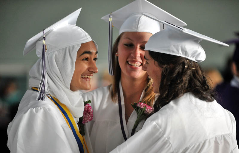 HAPPINESS: Waterville Senior High School graduates Syra Khan, left, Whitney Scott, center, and Annesley Beringer, share some laughs backstage before the commencement ceremony at Wadsworth Gymnasium at Colby College in Waterville on Thursday.