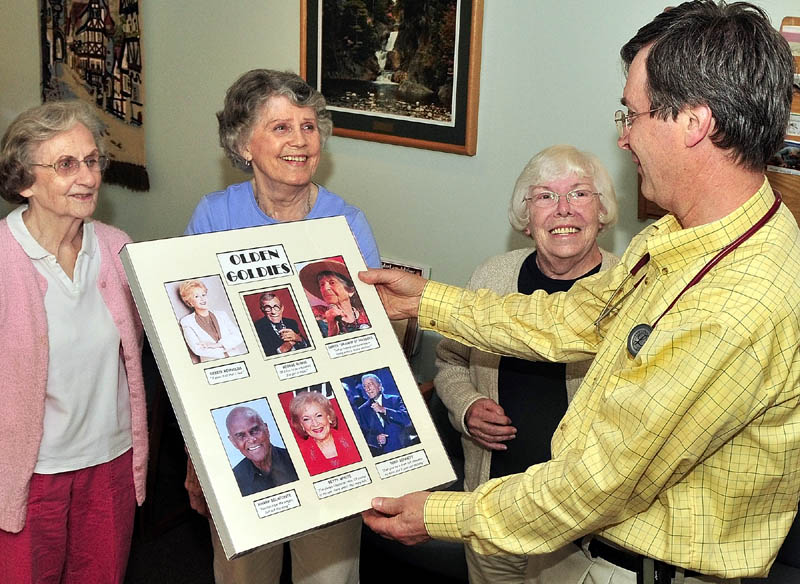 GOLDEN GIRLS: From left, Barbara Tracy, Marilyn Canavan and Betty Goulette surprise Dr. Roland Knausenberger, of Litchfield, with a poster in his office this week at Inland Medical Associates in Waterville.