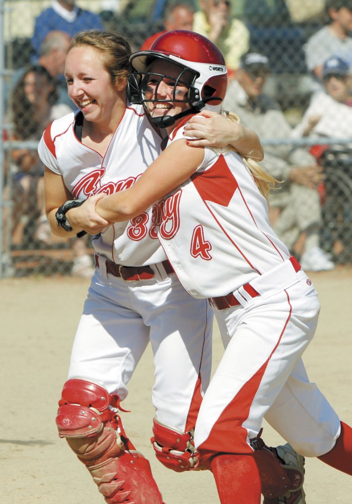 LET ME HELP: Cony’s Nicole Rugan, left, hugs Alyssa Brochu after Brochu scored the Rams’ second run in the fourth inning in the Class A softball state championship game Saturday at St. Joseph’s College in Standish.