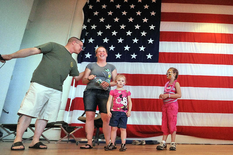 1st Sgt. Michael Peacock, far left, leads people in singing Happy Birthday to Spc. Charilyn Campbell, center left, with her nieces Ayla Nash, 3, center, and Aubriana Nash, 8, during a family barbeque at the Waterville Armory for soldiers in the 488th Military Police Company preparing to deploy to Afghanistan next week..
