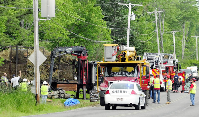 Investigators look over the logging truck where a man was electrocuted Friday afternoon on Spears Corner Road in West Gardiner.