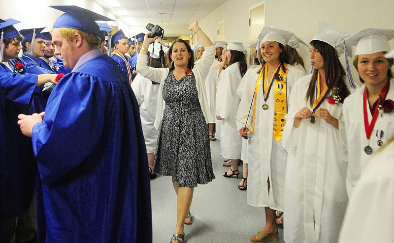 BACK UP: Dee Porter, one of the senior class advisers, tells Erskine Academy graduates to back up in the hallway as they line up before graduation on Friday at the Augusta Civic Center.