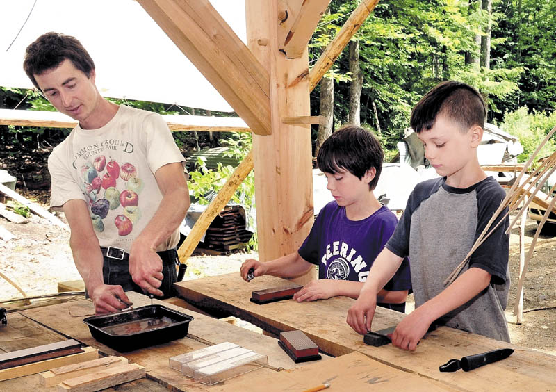 PRETTY SHARP: Chris Knapp of the Koviashuvik School in Temple shows Calvin Soule, left, and his brother Ezra how to sharpen knives on Thursday.