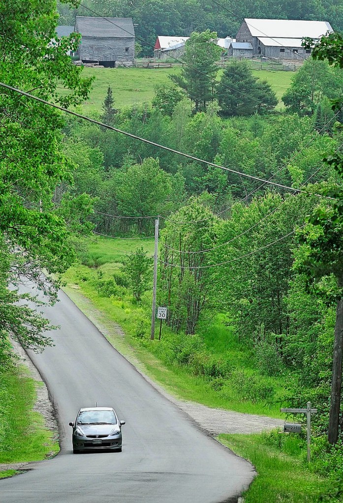 A car drives below the 256-acre Meadow Brook Farm on Bamford Hill Road in Fayette on Tuesday afternoon. The Kennebec Land Trust just completed a deal which allows a conservation easement and opens some areas to the public.