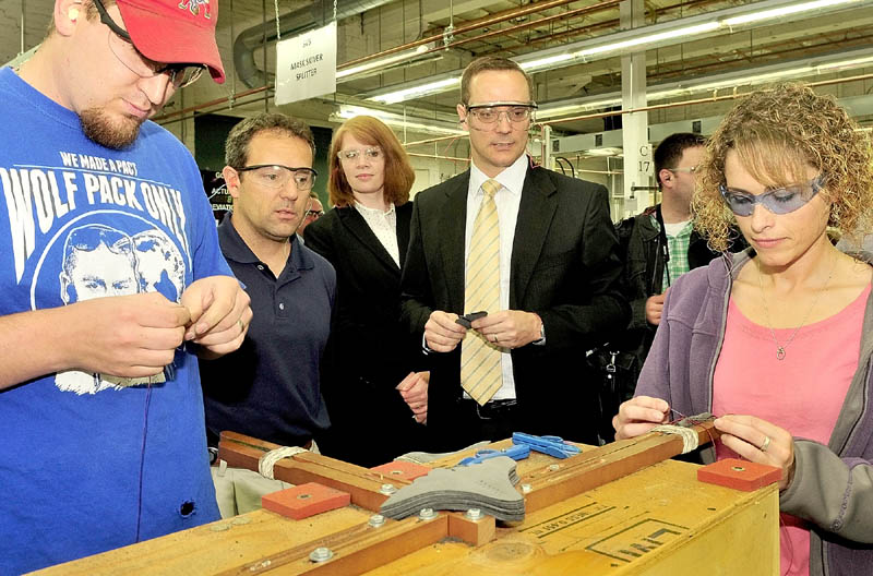 TOUR: U.S. Department of Commerce officials Paul Piquado, center, and Kim Glas, third from left, tour the New Balance factory in Skowhegan on Thursday. Plant Manager Patrick Welch, second from left, speaks as employees Ben Howe and Lindsay Ireland hand-lace footwear.