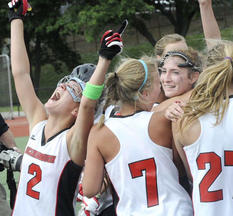 Jess Meader, left, leads the celebration Saturday after Scarborough continued its domination of Class A girls’ lacrosse, beating Brunswick 11-9 for its third consecutive state championship.