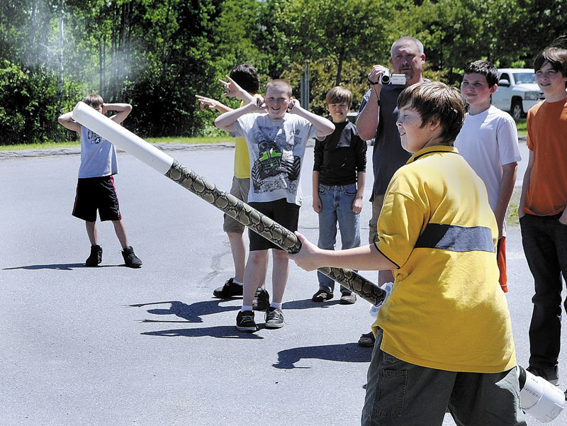 Classmates cover their ears as Robert Shaw fires his potato launcher that he and his father Chris Shaw built for the Ruby Team Science Fair and Invention Convention on Friday at Maranacook Middle School in Readfield. Taylor Anderson and his father Devin Anderson also built a launcher with the Shaws. There were 45 students in 6th, 7th and 8th grades participating in the event.