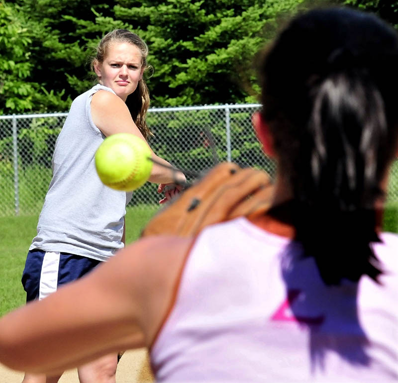 Staff photo by David Leaming Nokomis pitcher Sara Packard throws to player Drew Graves during practice on Monday.