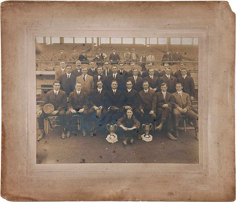 This 1912 photo made by Carl Horner and released July 24, 2012,by Heritage Auctions in Dallas shows the world champion Boston Red Sox team posing with two silver World Series trophies along the first base line in Fenway Park in Boston. The trophy on the left, presented to manager Jake Stahl, front row fifth from left, is scheduled to be auctioned along with this photo on Aug. 2, 2012, at Camden Yards in Baltimore. The trophy on the right was presented to team owner James McAleer, sixth from left front row, and is presumably lost to history. Also in the photograph is Boston Mayor John "Honey Fitz" Fitzgerald, fourth from left front row, grandfather of President John F. Kennedy. (AP Photo/Carl Horner, via Heritage Auctions)