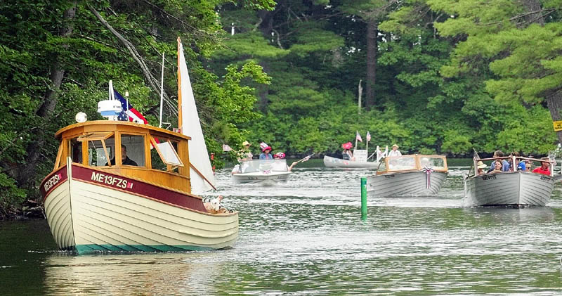 Boats parade down Mill Stream on Wednesday during Independence Day events in Belgrade Lakes village.
