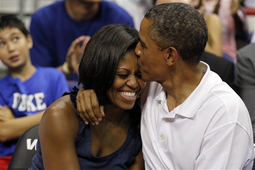 President Barack Obama kisses first lady Michelle Obama after kissing her for "Kiss Cam" in the second half while attending the Olympic men's exhibition basketball game between Team USA and Brazil on Monday.
