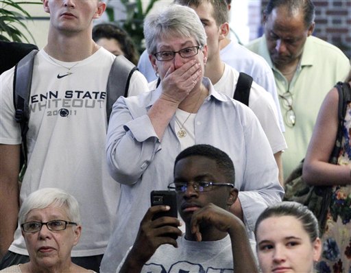 Susan DelPonte, center, of State College, Pa., reacts to a television in the HUB on the Penn State University main campus in State College, Pa., as the NCAA sanctions against the Penn State University football program are announced on Monday.
