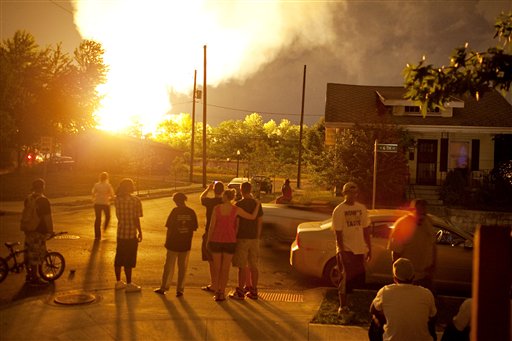 People watch flames shoot up from a freight train that derailed and some cars burst into flames, early this morning in Columbus Ohio. The accident happened at about 2 a.m. in a mixed-use part of the city, and people living within a one-mile radius of the blast were evacuated.