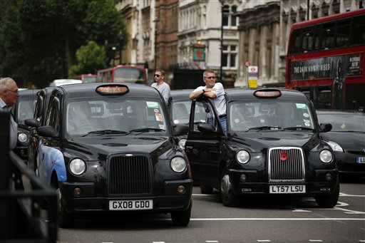London taxi drivers park their cabs on the junction of Whitehall and Parliament Square on Tuesday, as they take part in a protest to jam traffic in reaction to not being allowed to use the Olympic driving lanes in London.