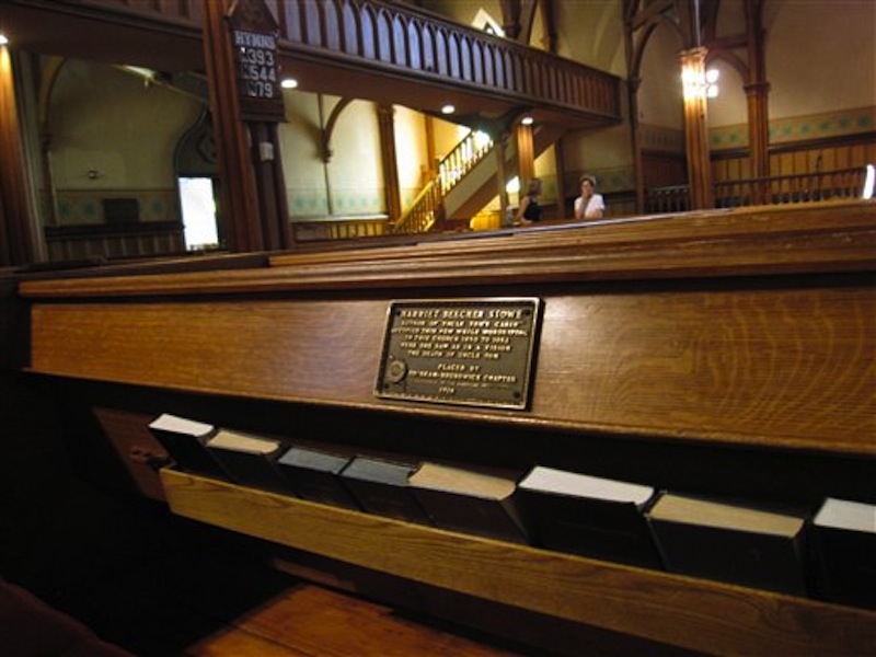 This July 13, 2012 photo shows the marker on a pew at First Parish Church in Brunswick, Maine, where "Uncle Tomís Cabin" author Harriet Beecher Stowe sat in 1851 when she had a vision of a scene for the book. The church, a Gothic Revival building that dates to the 1840s, is one of 14 sites in Brunswick on the National Register of Historic Places. (AP Photo/Beth Harpaz)