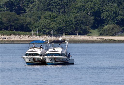 Two police boats are stationed near the opening to the Long Island Sound in Lloyd Harbor, N.Y., today. Investigators are trying to learn more about the crucial seconds before a yacht capsized off Long Island, killing three children and leaving 24 others scrambling for their lives.
