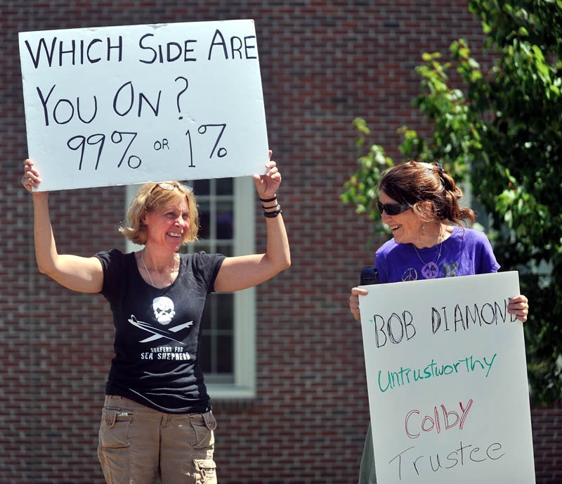 Kim Cormier, left, of Benton, and Lucia Robinson, of Whitefield, stand outside the Diamond Building at Colby College on Mayflower Hill Drive calling for chairman of the college's Board of Trustees Robert E. Diamond Jr. to resign and for Colby for remove him from their board and give back Diamond's donations.