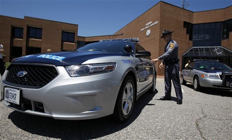 Virginia State Police Sgt G. Michael Jenkins, Jr., at Virginia State Police headquarters Friday, June 15, 2012, checks out one of the new Ford Taurus police cruisers that will replace the Crown Victoria models, right. (AP Photo/Richmond Times-Dispatch, Bob Brown)