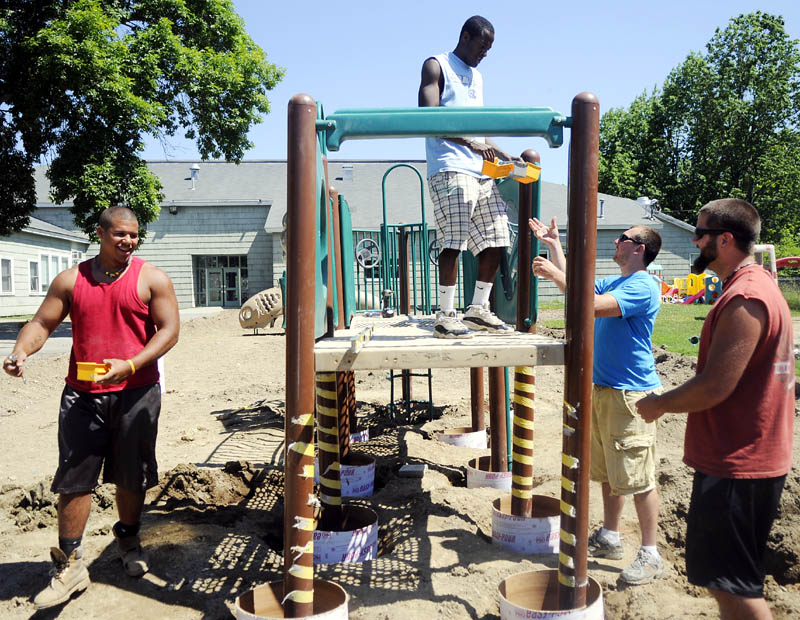Eddie Donnell, left, Tookie Amosun, Cody Peckham and Ethan Stanchfield assemble a new playground Tuesday at the Boys and Girls Club in Gardiner. The Club spent four years raising funds for the playground.