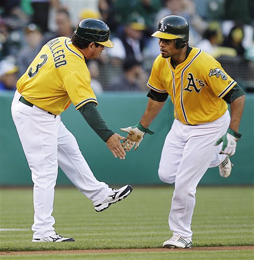 Oakland Athletics' Coco Crisp, right, is congratulated by third base coach Mike Gallego (3) after Crisp hit a home run off Boston Red Sox's Jon Lester in the first inning of a baseball game, Tuesday, July 3, 2012, in Oakland, Calif. (AP Photo/Ben Margot)