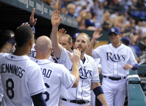 Tampa Bay Rays' Jeff Keppinger, center, celebrates with teammates in the dugout after scoring on a sacrifice fly by Elliot Johnson during the seventh inning of a baseball game against the Boston Red Sox on Saturday, July 14, 2012, in St. Petersburg, Fla. (AP Photo/Brian Blanco)