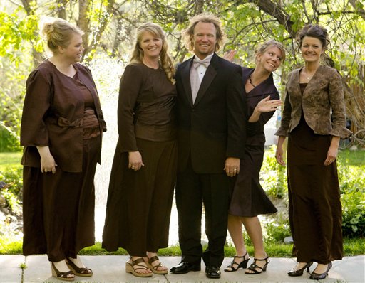 In this undated file photo provided by TLC, Kody Brown, center, poses with his wives, from left, Janelle, Christine, Meri, and Robyn in a promotional photo for TLC's reality TV show, "Sister Wives." A Utah county attorney says he will not pursue criminal charges against this polygamous family made famous by a reality TV show. A federal judge is set to decide whether to allow a lawsuit to move forward that challenges the constitutionality of Utah's bigamy law.