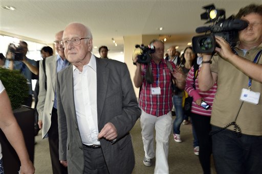 British physicist Peter Higgs, left, arrives to hear about the latest update in the search for the Higgs boson at the European Organization for Nuclear Research (CERN) in Meyrin near Geneva, Switzerland, today.