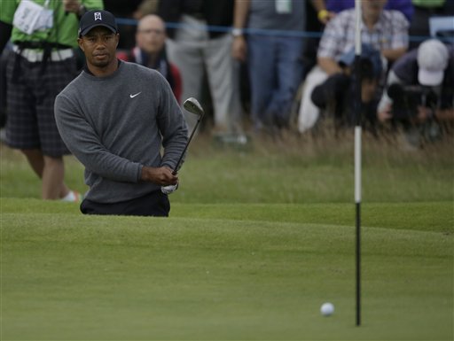 Tiger Woods of the United States watches his chip shot out of the bunker on the 18th green to go on to drop into the hole at Royal Lytham & St Annes golf club during the second round of the British Open Golf Championship, Lytham St Annes, England, Friday, July 20, 2012. (AP Photo/Chris Carlson)